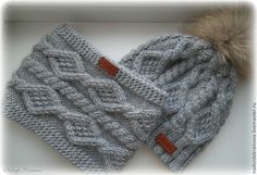 two gray knitted hats with fur pom