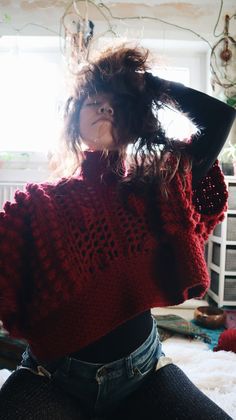 a woman with long hair wearing a red sweater