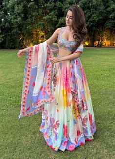 Elevate your wardrobe with the enchanting Summer Bloom Lehenga Set. This exquisite ensemble features a beautifully printed lehenga in luxurious satin organza, adorned with vibrant floral motifs that exude grace and elegance. The set includes a meticulously embroidered blouse that adds a touch of sophistication and glamour. Completing the look is a delicate organza dupatta, featuring matching prints and intricate embroidery along the borders. Perfect for destination weddings, festive celebrations Floor-length Lehenga With Printed Motifs For Wedding, Diwali Lehenga With Digital Print On Georgette, Wedding Sharara With Printed Motifs In Georgette, Wedding Sharara With Printed Motifs, White Anarkali Lehenga With Floral Print, Anarkali Choli With Digital Print For Party, Party Anarkali Choli With Digital Print, Bollywood Style Lehenga With Printed Motifs For Reception, Wedding Sharara With Floral Print For Navratri