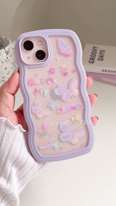 a person holding up a phone case with butterflies on it