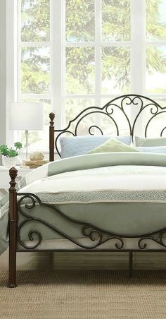 a metal bed frame in a bedroom with white walls and carpeted flooring next to windows