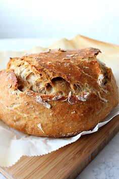 a loaf of bread sitting on top of a wooden cutting board