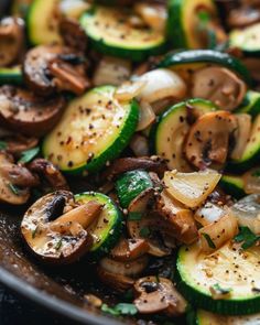 sliced zucchini and mushrooms in a skillet with seasoning sprinkled on top