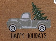 a truck with a christmas tree on the back is shown in front of a door mat