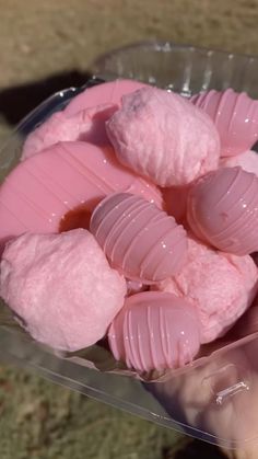 a person holding a plastic container filled with pink candy