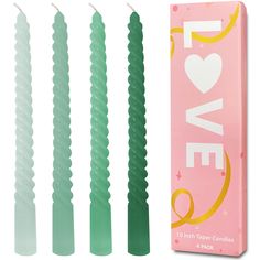 four green candles in a pink box with the words love on it and three different colors