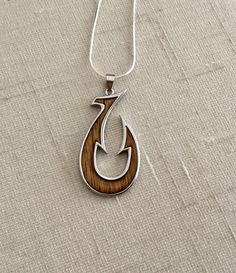 "Solid .925 Sterling Silver Hawaiian Koa Wood Unisex Hook Makau Necklace. FREE Sterling Silver box chain included in your choice of length. The size large at about 1.8\" long and 0.9\" wide. Worn by both Men & Women In our Hawaii stores. The High-polished Sterling silver finish is both stunning and very durable. This will shine for years to come. --Koa Wood trees are grown in the Big Island. When handcrafted into jewelry it's diverse colors and textures make each piece unique. It is often ex Father's Day Nickel Free Silver Jewelry, Symbolic Necklace For Father's Day Gift, Anniversary Jewelry With Lobster Clasp In Stainless Steel, Anniversary Stainless Steel Jewelry With Lobster Clasp, Father's Day Silver Box Chain Jewelry, Father's Day Silver Nickel-free Jewelry, Father's Day Pendant Jewelry With Box Chain, Unique Jewelry With Fish Hook For Gift, Father's Day Engraved Pendant Jewelry