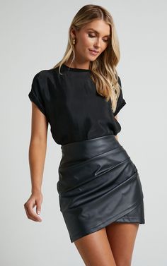 Ashlyn Mini Skirt - Faux Leather Overlap Skirt in Black Sleek Mini Skirt For Date Night, Asymmetrical Solid Mini Skirt For Night Out, Sleek Lined Mini Skirt For Date Night, Sleek Pencil Skirt Bottoms For Going Out, Sleek Lined Skirt For Date Night, Solid Color Sleek Mini Skirt For Night Out, Sleek Pencil Skirt For Going Out, Sleek Skirt For Going Out In Spring, Solid Color Skort For Fall Night Out