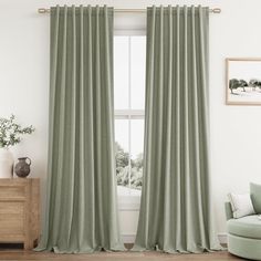 a living room with a couch, chair and window covered in light green drapes