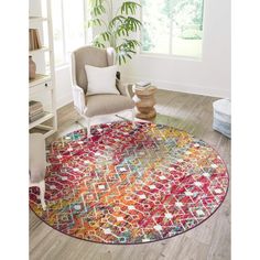 a round rug with an orange, red and blue design on it in a room