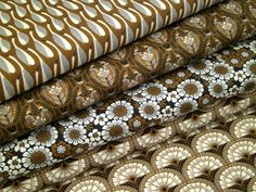 four different fabrics are stacked on top of each other, one is brown and the other is white