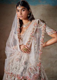 Ivory raw silk bridal lehenga with thread and pearl embroidery paired with two tulle dupattas and an embroidered blouse. Off White Wedding Sets With Dupatta, Bollywood Style Off White Sharara For Wedding, Bollywood Pearl Embroidered Dupatta For Reception, Wedding Saree With Pearl Embroidery And Traditional Drape, Off White Sharara With Sheer Dupatta For Reception, Off-white Sharara With Sheer Dupatta For Reception, Wedding Anarkali Set In Raw Silk With Pearl Embroidery, Traditional Drape Off White Lehenga For Wedding, Off White Traditional Drape Lehenga For Wedding