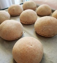 several doughnuts on a baking sheet ready to be baked into buns or muffins