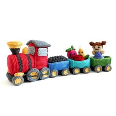 a crocheted toy train with fruits and vegetables on the front is shown in three different colors