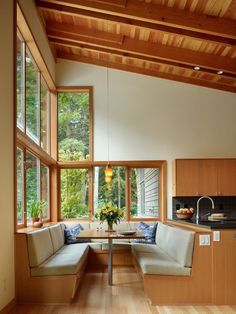 a living room filled with furniture next to a window covered in wood planked walls