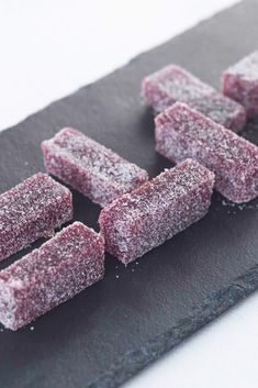 several pieces of food sitting on top of a cutting board with powdered sugar over them