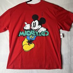 This Disney Parks Men's T-Shirt Is A Must-Have For Any Fan Of Mickey Mouse And Co. The Graphic Print Features The Beloved Character In A Bold And Vibrant Design. The Shirt Is Made Of High-Quality Cotton Knit Fabric, Ensuring Comfort And Durability. It Is Machine Washable, Making It Easy To Care For. The Shirt Has Short Sleeves And A Crew Neck, With A Regular Fit That Is True To Size. It Is Available In Xl Size, And The Color Is A Striking Shade Of Red. This Shirt Is Perfect For Casual Outings Or Disney Short Sleeve T-shirt For Streetwear, Short Sleeve Disney T-shirt For Streetwear, Casual Mickey Mouse Crew Neck T-shirt, Mickey Mouse Cotton T-shirt For Streetwear, Retro Mickey Mouse Short Sleeve Tops, Disney Blue Top For Streetwear, Mickey Mouse Short Sleeve Fan Merchandise Shirt, Mickey Mouse Short Sleeve Shirt, Mickey Mouse Short Sleeve Top For Fans