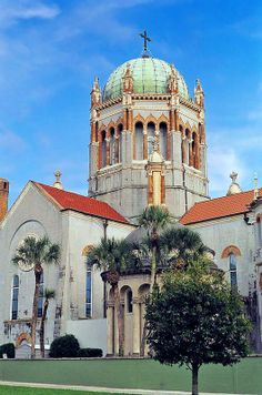 an old building with a dome on top and palm trees in front