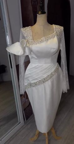 a white wedding dress on display in front of a mirror