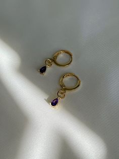 "18K gold plated teardrop amethyst, emerald drops huggie hoops which are beautifully shiny under the sunlight. *Nickel free 👀 Details 👀 * Materials : 18K gold plated brass, Amethyst, Emerald * Hoop style * 10mm hoop diameter (Inner diameter : 8mm) Crystal charm : 3 mm (w) x 6 mm (h) * Product is non-returnable for hygiene ⚠️Tips for caring⚠️ -Keep jewelry dry (Avoid contact liquid) -Store difference type of jewelry separately -Store jewelry in a small zip lock bag 📦 Packaging 📦 These earring Anniversary Gold Plated Teardrop Huggie Earrings, Anniversary Teardrop Gold Plated Huggie Earrings, Anniversary Teardrop Gold-plated Huggie Earrings, Purple Hoop Earrings As Gift, Gold Amethyst Dainty Earrings, Purple Hoop Jewelry For Gift, Dainty Gold Amethyst Earrings, Gemstone Dangle Huggie Earrings Gift, Gold Plated Teardrop Huggie Earrings