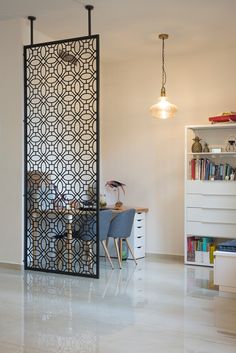 a room divider in the middle of a living room with a table and chairs