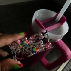 a person holding a candy bar in front of a cup and container with the word love spelled on it