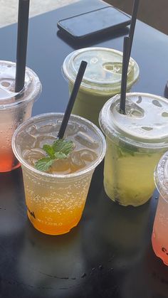 four different types of drinks sitting on top of a black table next to each other