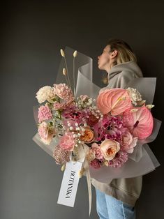 a woman holding a bouquet of flowers in front of her face with a name tag on it