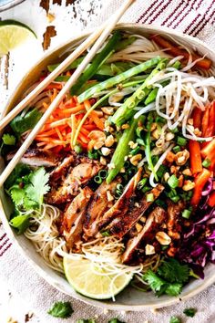 a bowl filled with meat, vegetables and noodles