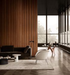 a living room with wooden walls and flooring next to a large glass window on the wall