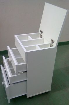 a white cabinet with drawers is on the floor