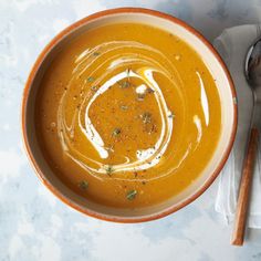 a bowl filled with soup next to a spoon and napkin on top of a table