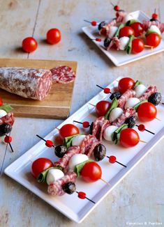 small appetizers with meat, tomatoes and olives on a white plate