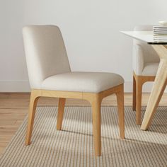 a dining room with a table and chair next to a white plate on the floor