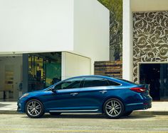 a blue car parked in front of a building