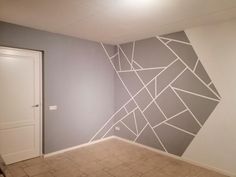 an empty room with a painted wall in the middle and tile flooring on the other side