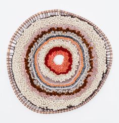 a white and red circular rug on top of a table