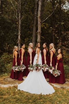 the bride and her bridesmaids pose for a photo in front of some trees