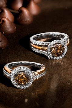 two gold and silver wedding rings with brown diamonds on the top, surrounded by chocolate beans