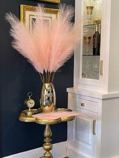 there is a vase with some pink feathers in it