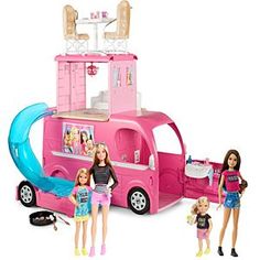 two barbie dolls are standing next to a pink camper with a pool and slide