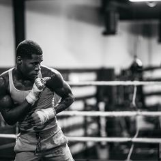 a black and white photo of a man boxing