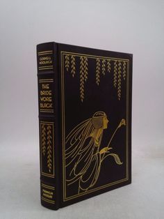 a black and gold book with an image of a woman holding a plant in her hand