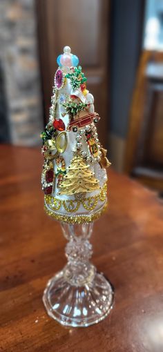 a glass christmas tree sitting on top of a wooden table