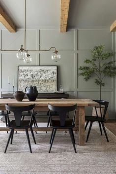 a dining room table with chairs and a vase on it