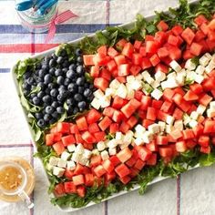 a platter filled with watermelon, blueberries and feta cheese