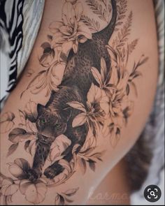 a woman's thigh with a cat and flowers on it