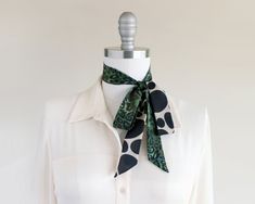 "A beloved style in the collection, this unique pattern play scarf serves as the perfect statement accessory that will give any classic look a twist. Composed in a meticulous mix of two original prints designed by Cinne herself. Wear around your neck, in your hair, tied on your favorite bag, or around your wrist. Find more styling examples in the second to last photo. Constructed entirely by hand with love and attention to every detail. . . . . . . . . . . . . . . . Ready to ship. . . . . . . . Chic Green Scarf For Gift, Trendy Spring Neckwear For Gifts, Trendy Scarf Neckwear As Gift, Chic Adjustable Scarves With Ties, Chic Scarves With Ties, Chic Neckwear Ties As Gift, Chic Ties As A Gift, Womens Neck Tie, Dark Green Scarf