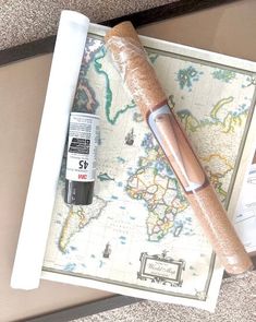 a map with a pen and glue on it next to an empty roll of tape