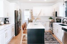 a kitchen with white cabinets and black appliances